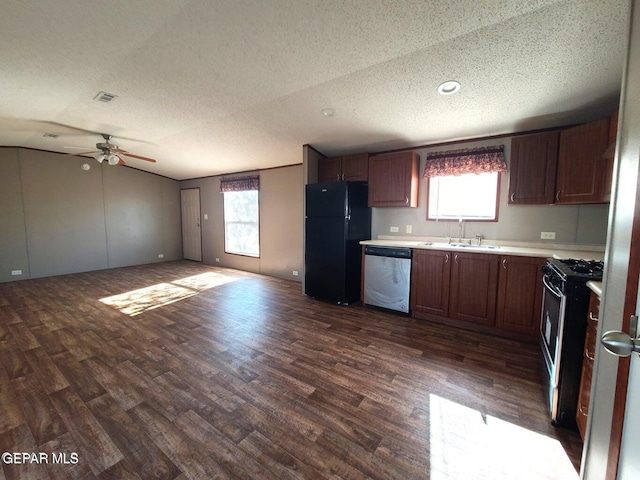 kitchen with dark wood-style flooring, a sink, a textured ceiling, and appliances with stainless steel finishes