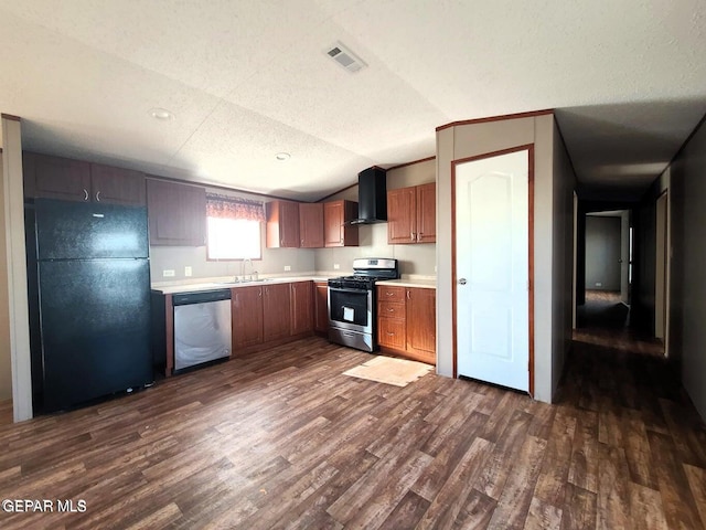 kitchen featuring lofted ceiling, wall chimney exhaust hood, dark wood-type flooring, sink, and appliances with stainless steel finishes