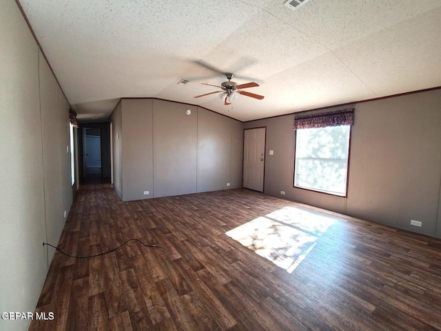 unfurnished room with ceiling fan, a textured ceiling, vaulted ceiling, and dark hardwood / wood-style floors