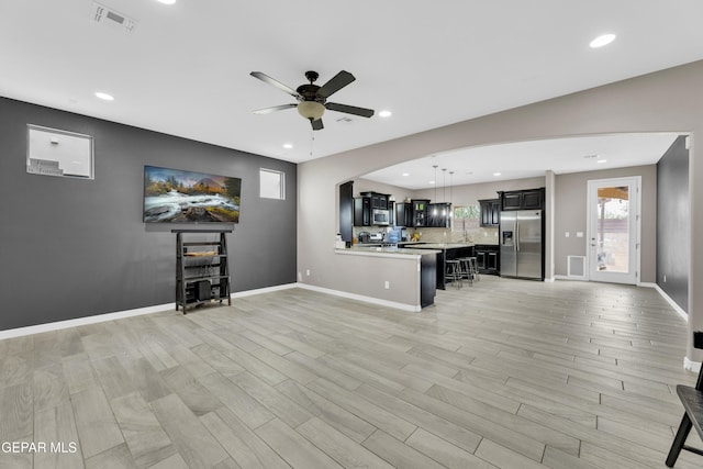 unfurnished living room featuring light hardwood / wood-style floors and ceiling fan