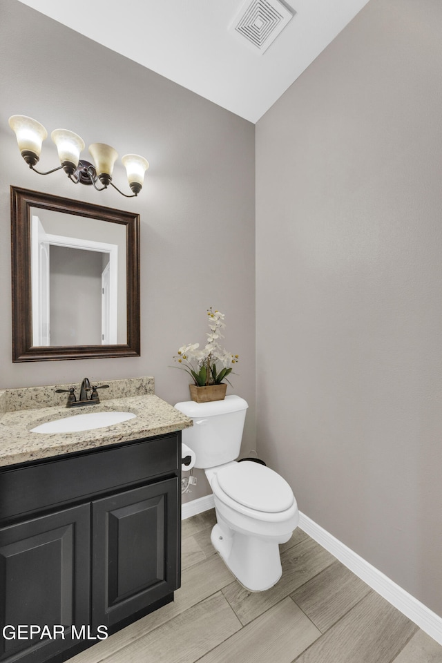 bathroom featuring toilet, vanity, and wood-type flooring