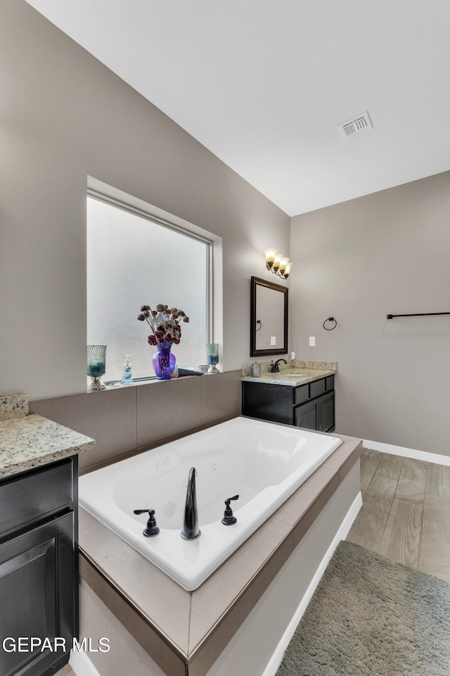 bathroom with vanity, a bathing tub, and hardwood / wood-style floors