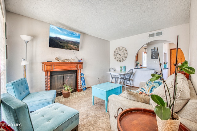 carpeted living room featuring a textured ceiling and a brick fireplace