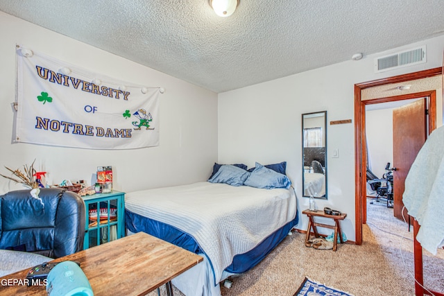 bedroom featuring carpet floors and a textured ceiling