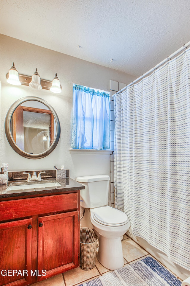 bathroom with tile patterned floors, vanity, a textured ceiling, and toilet