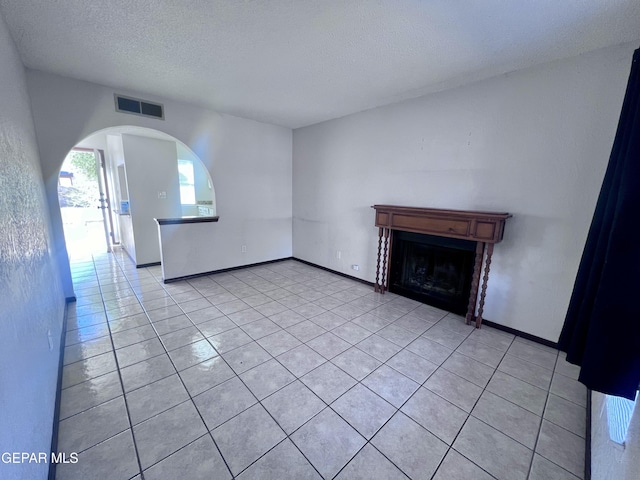 unfurnished living room featuring light tile patterned floors and a textured ceiling