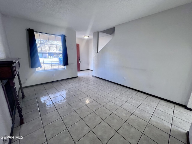 empty room featuring light tile patterned floors and a textured ceiling