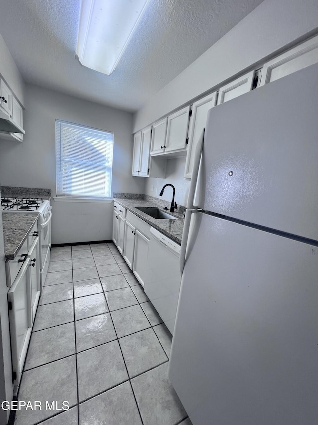 kitchen featuring white cabinetry, sink, a textured ceiling, white appliances, and light tile patterned floors