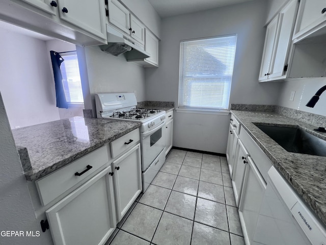 kitchen featuring white cabinets, white appliances, dark stone counters, and sink