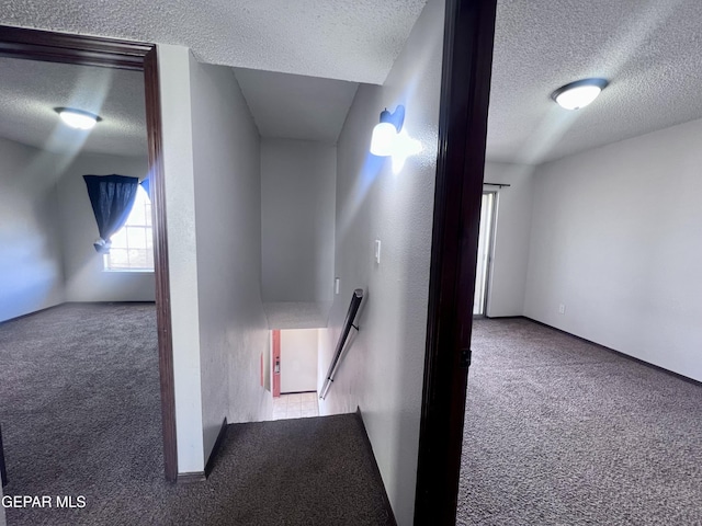 hallway with carpet floors and a textured ceiling