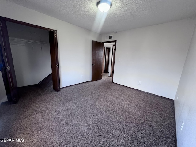 unfurnished bedroom with carpet, a textured ceiling, and a closet