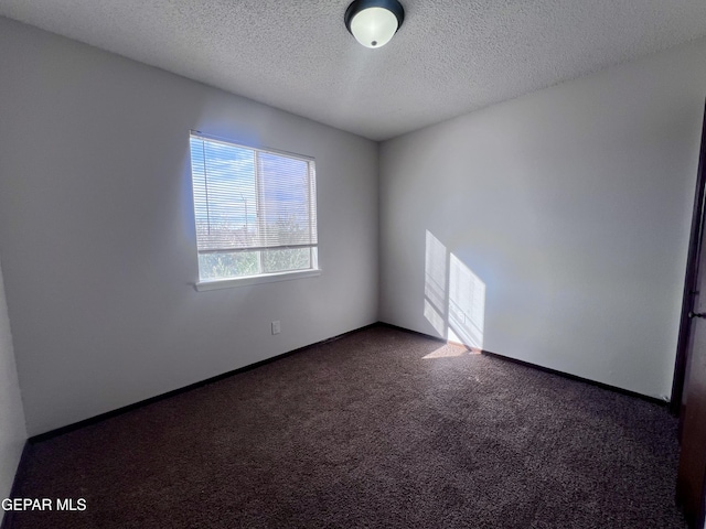 carpeted empty room with a textured ceiling