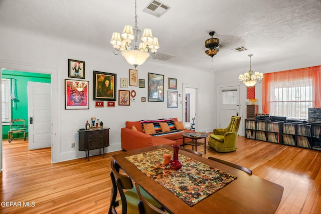 living room featuring a chandelier, a textured ceiling, and light hardwood / wood-style floors