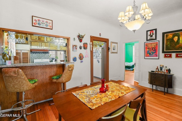 dining space with a notable chandelier and light wood-type flooring