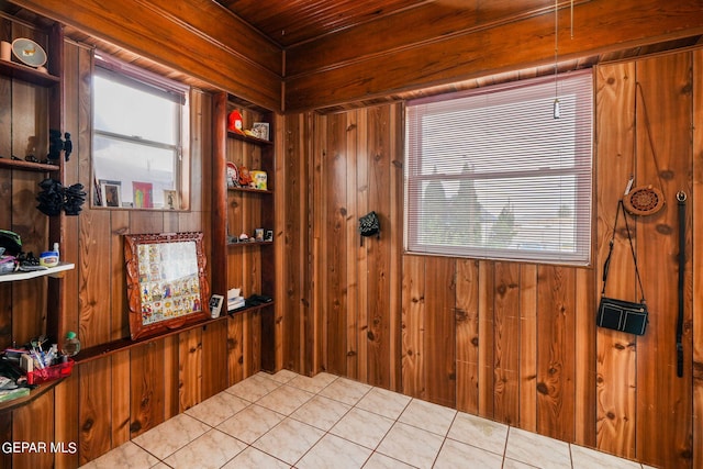 interior space featuring wood ceiling, wood walls, and light tile patterned floors