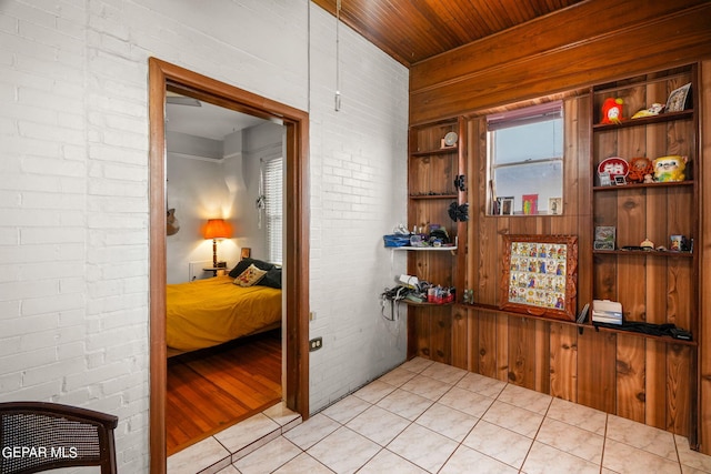 corridor featuring wood ceiling, brick wall, and light tile patterned floors