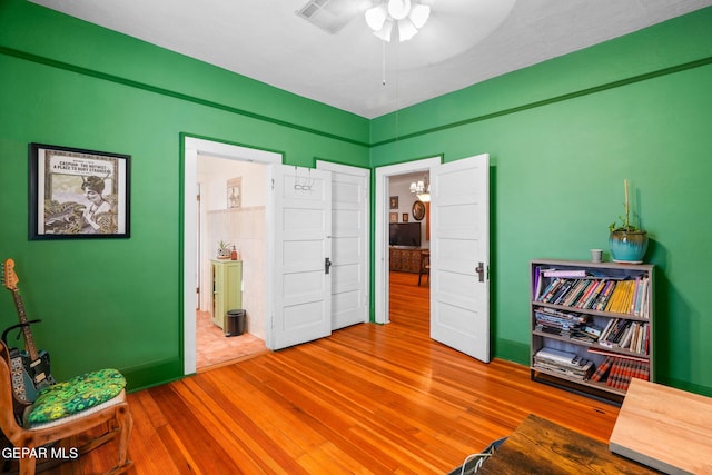 interior space with wood-type flooring and ceiling fan