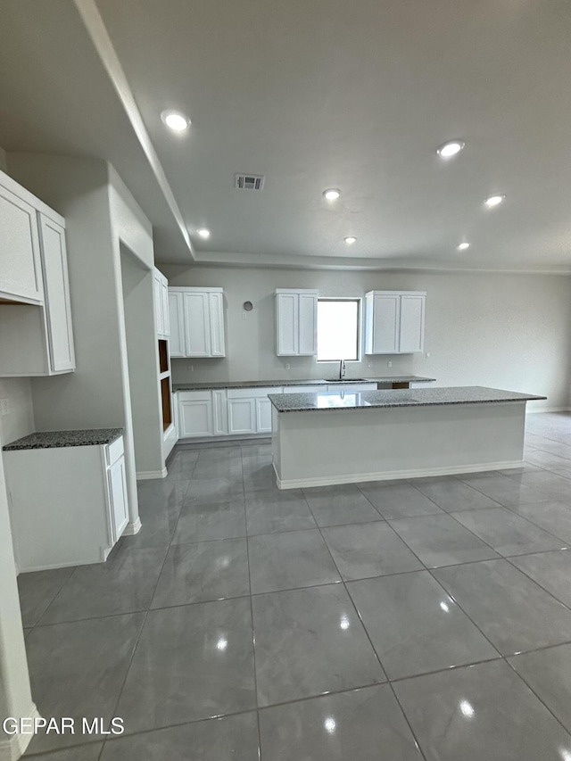 kitchen featuring recessed lighting, visible vents, white cabinets, and a center island