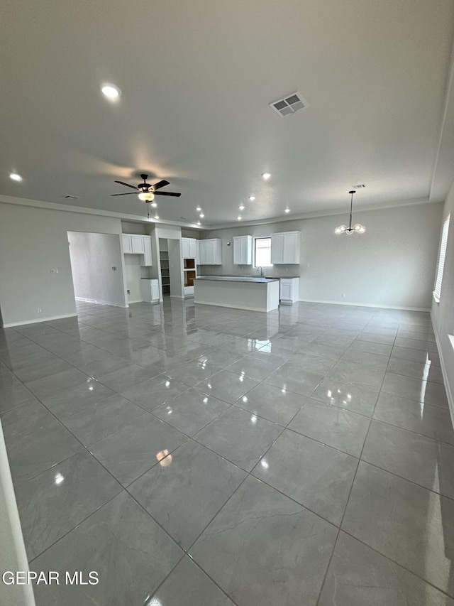 unfurnished living room featuring visible vents, crown molding, and baseboards