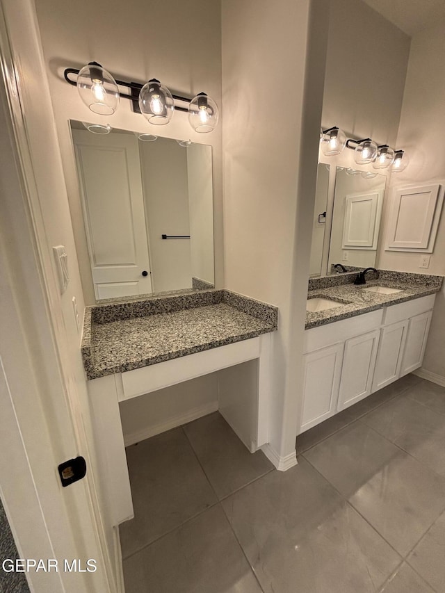 bathroom with vanity, tile patterned floors, and baseboards