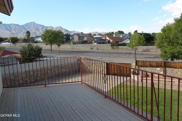 wooden deck with a yard and a mountain view