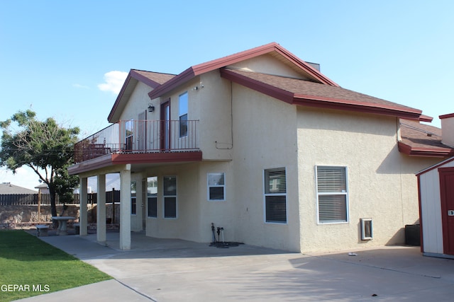 back of property featuring a patio and a balcony