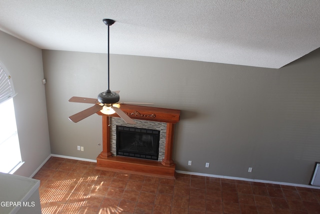 unfurnished living room with ceiling fan, a textured ceiling, vaulted ceiling, and a fireplace