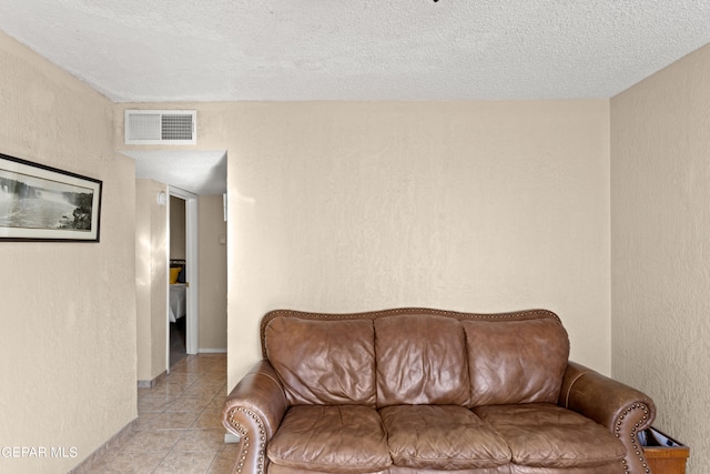 living room with a textured ceiling and light tile patterned floors