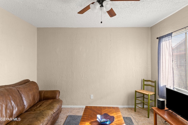 living room with ceiling fan, a textured ceiling, and light tile patterned floors