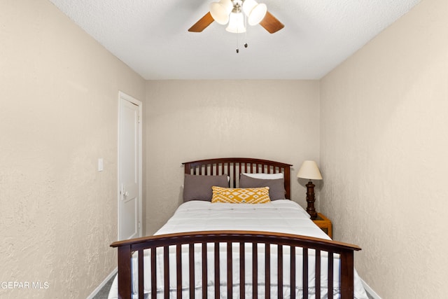 bedroom with ceiling fan and a textured ceiling