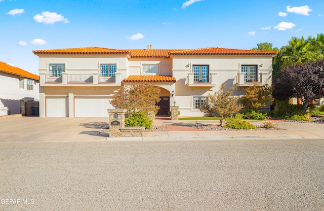 mediterranean / spanish-style house with a garage and a balcony