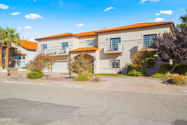 mediterranean / spanish-style home with a garage and a balcony