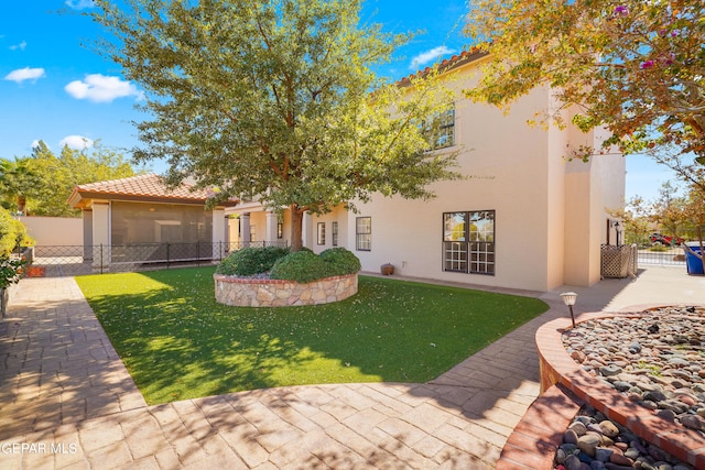 mediterranean / spanish house featuring a front lawn and a patio area