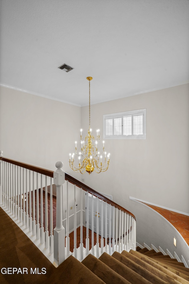 stairs featuring carpet floors and a notable chandelier