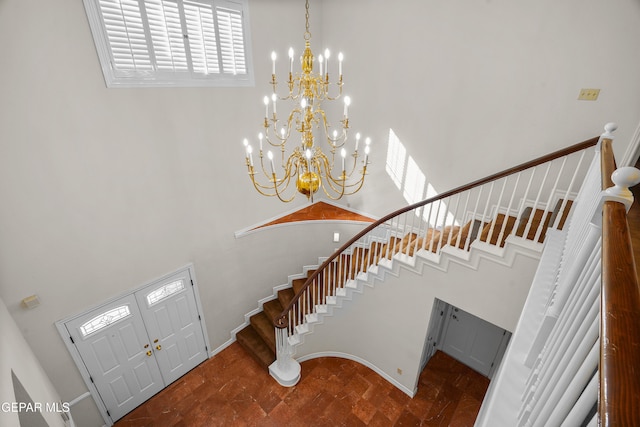 foyer featuring a towering ceiling and a notable chandelier