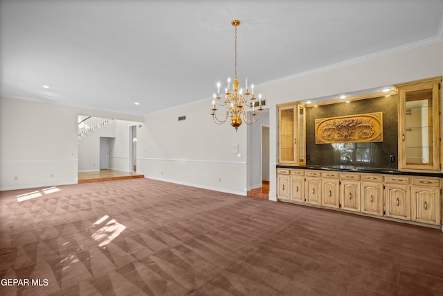 unfurnished living room featuring crown molding, an inviting chandelier, and carpet floors