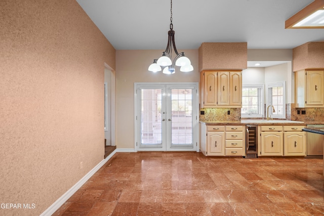 kitchen with wine cooler, stainless steel dishwasher, a chandelier, pendant lighting, and decorative backsplash