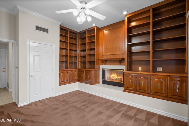 unfurnished living room with ceiling fan, light carpet, and ornamental molding