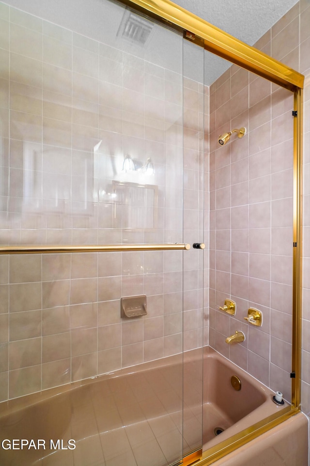 bathroom with tiled shower / bath combo and a textured ceiling