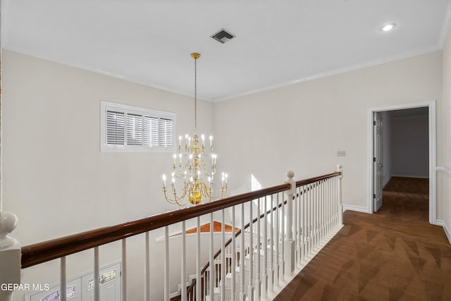 hall with a notable chandelier, dark carpet, and crown molding