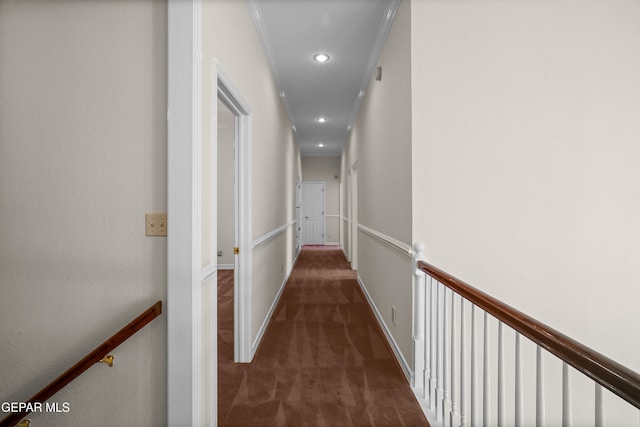 corridor featuring dark colored carpet and ornamental molding