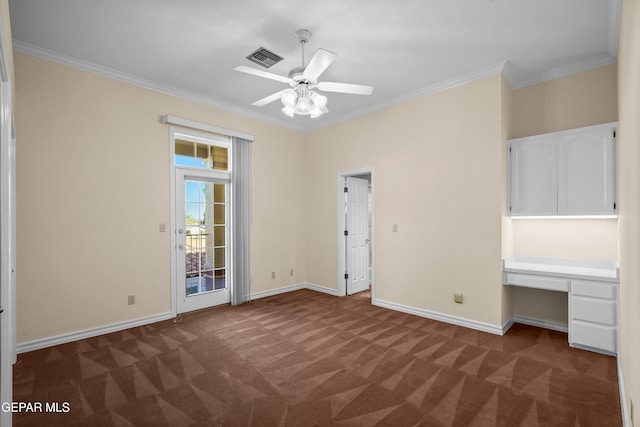 unfurnished bedroom featuring access to outside, built in desk, ornamental molding, dark colored carpet, and ceiling fan