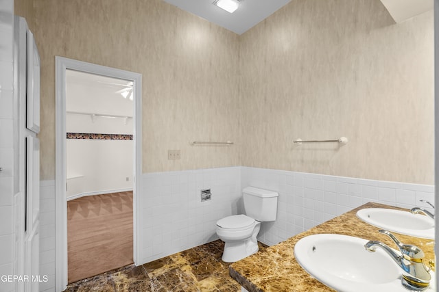 bathroom featuring tile walls, vanity, and toilet