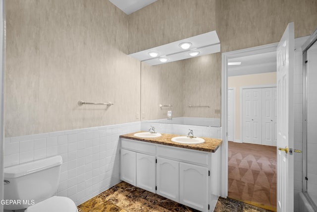 bathroom featuring tile walls, vanity, and toilet