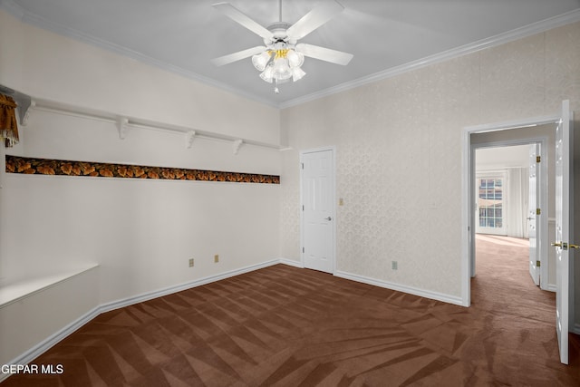 empty room with dark colored carpet, ceiling fan, and crown molding