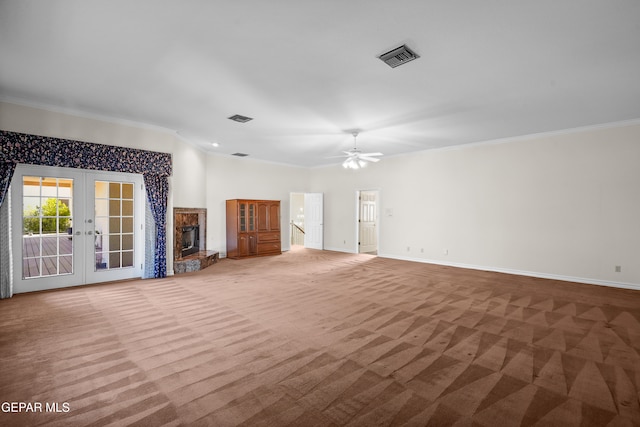 unfurnished living room featuring light carpet, ornamental molding, ceiling fan, a premium fireplace, and french doors