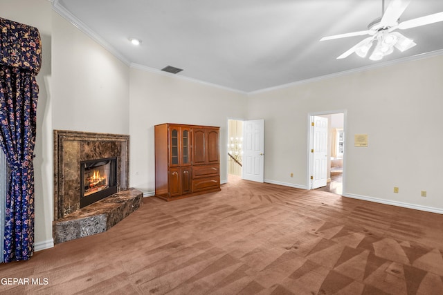 unfurnished living room with ornamental molding, a fireplace, light colored carpet, and ceiling fan