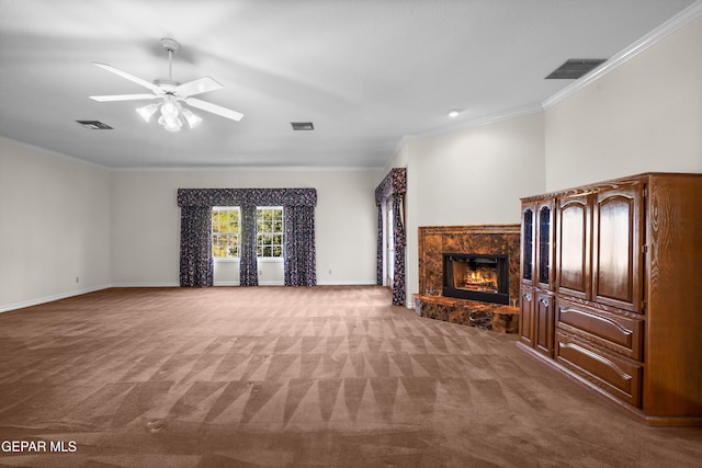 unfurnished living room featuring a fireplace, ceiling fan, crown molding, and carpet floors