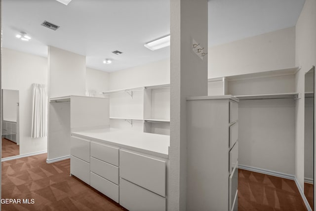 spacious closet featuring dark carpet