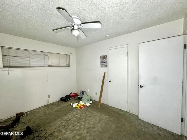 unfurnished bedroom with ceiling fan, concrete floors, and a textured ceiling